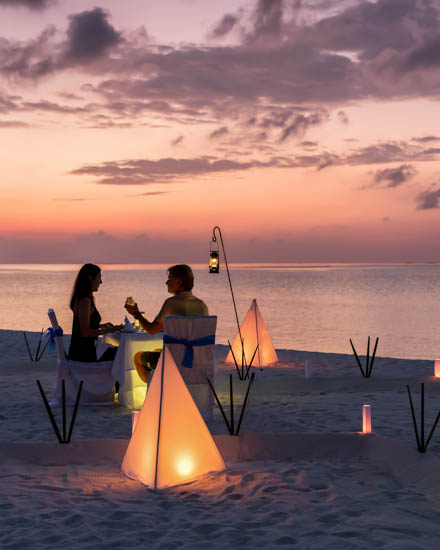 Romantisches Paar sitzt bei einem privatem Abendessen am tropisc