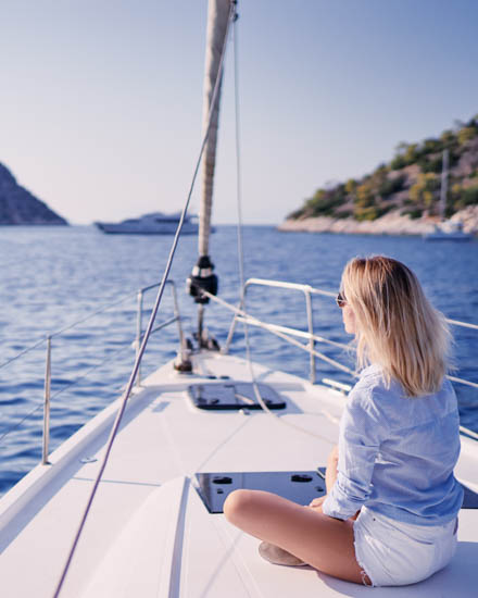 Luxury travel on the yacht. Young happy woman on boat deck saili
